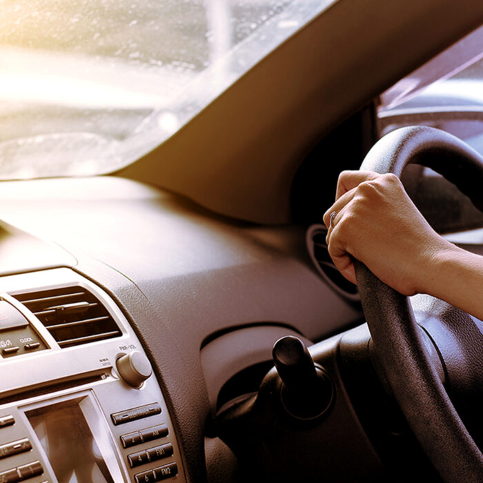 A car interior with a driver at the wheel.