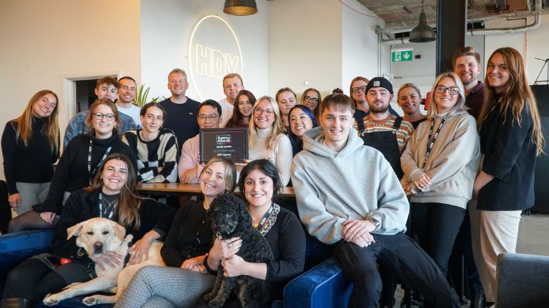 Group photo of the HDY Agency team holding up a new award